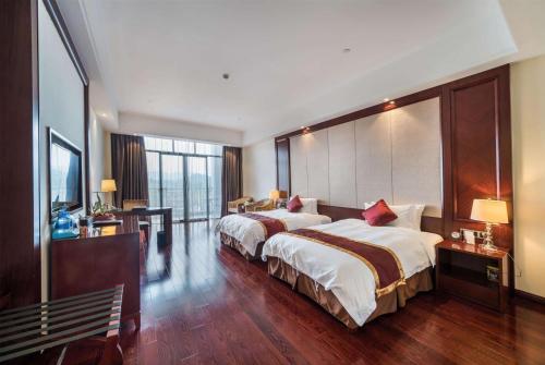 a hotel room with two beds and a large window at Wyndham Garden Wuyishan in Wuyishan