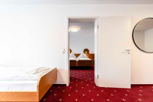 a hotel room with a bed and a mirror at Hotel & Gasthaus Löwen in Waldkirch