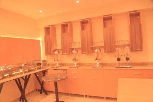 a kitchen with three sinks and a stool at Lego Star Hotel in Addis Ababa