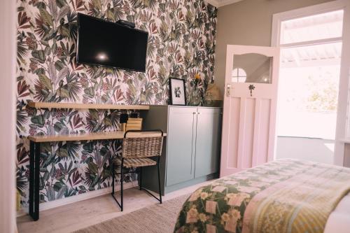 a bedroom with a bed and a tv on a wall at Sixteen On Latimer in East London