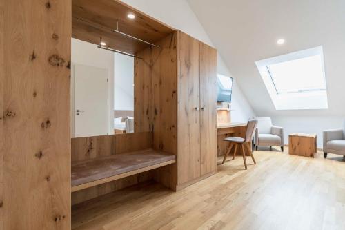 ヴァルトキルヒにあるHotel & Gasthaus Löwenの木製の壁の客室で、ベンチが備わります。