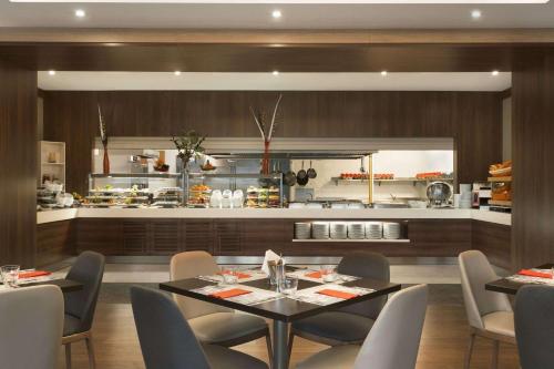 een eetkamer met een tafel en stoelen en een keuken bij Ramada Encore Istanbul Bayrampasa in Istanbul