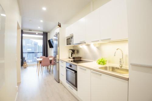 a kitchen with white cabinets and a sink at Apartment Aurinkoranta D7 saunallinen kaksio Kalajoki in Kalajoki