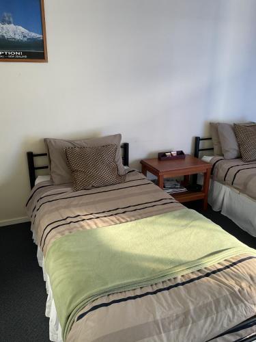 a bedroom with a large bed and a table at Tongariro River Retreat in Turangi