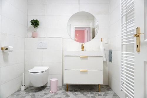 a white bathroom with a toilet and a mirror at Vibrant Design Apartments - Full Kitchen - Wi-Fi - 18 Mins to City Centre in Vienna