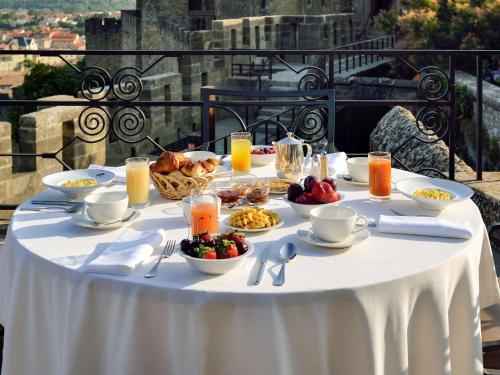 une table avec de la nourriture et des boissons sur un tissu de table blanc dans l'établissement Hotel de la Cité & Spa MGallery, à Carcassonne