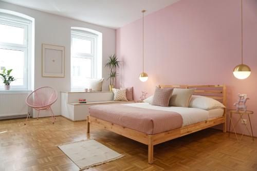 ein Schlafzimmer mit einem großen Bett und rosa Wänden in der Unterkunft Vibrant Design Apartments - Full Kitchen - Wi-Fi - 18 Mins to City Centre in Wien