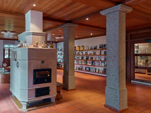 a large fireplace in a room with shelves of books at Hotel Glocke in Reckingen - Gluringen