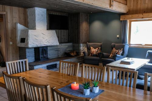a dining room with a table and a fireplace at Hemsetunet Apartments in Hemsedal
