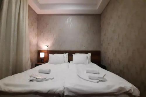a bedroom with a large white bed with towels on it at Hotel Goldenera in Kutaisi