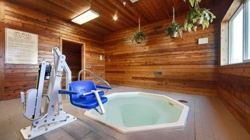 eine Whirlpool-Badewanne in einem Zimmer mit Holzwänden in der Unterkunft Best Western Of Huron in Huron