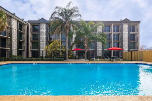 a large swimming pool in front of a building at Ramada by Wyndham Metairie New Orleans Airport in Metairie