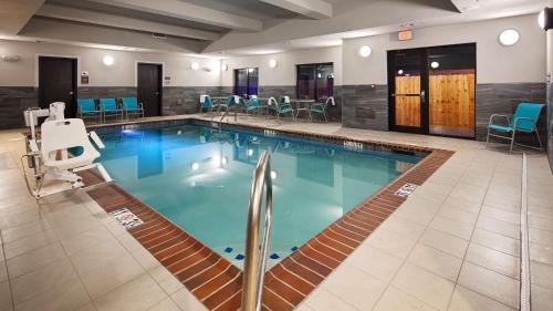 a large pool in a hotel with chairs and tables at Best Western Plus Prien Lake Hotel & Suites - Lake Charles in Lake Charles