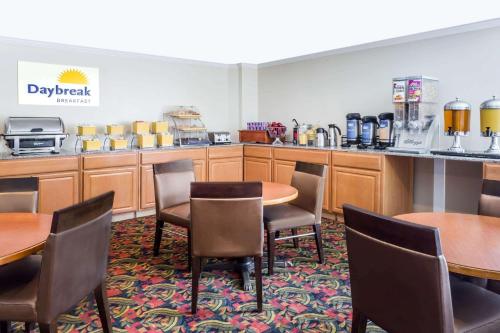 a dining room with tables and chairs and a kitchen at Days Inn by Wyndham Williamsburg Historic Area in Williamsburg