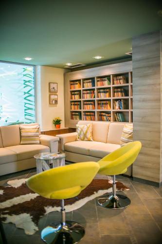 a living room with a couch and a yellow chair at Hotel Alpenblick Kreischberg in Sankt Lorenzen ob Murau
