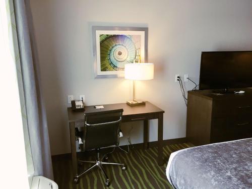 a hotel room with a desk with a lamp and a bed at Best Western Plus Prien Lake Hotel & Suites - Lake Charles in Lake Charles