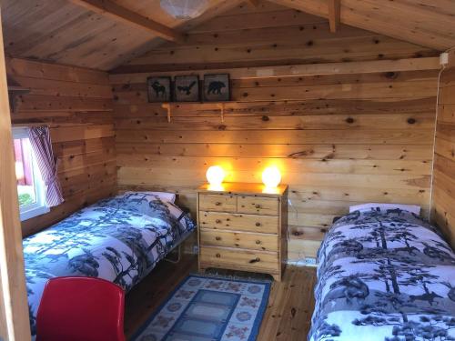 1 dormitorio con 2 camas en una cabaña de madera en Vakantiewoning aan het water en Råda