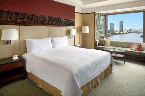 a hotel room with a large bed and a large window at Shangri-La Bangkok in Bangkok