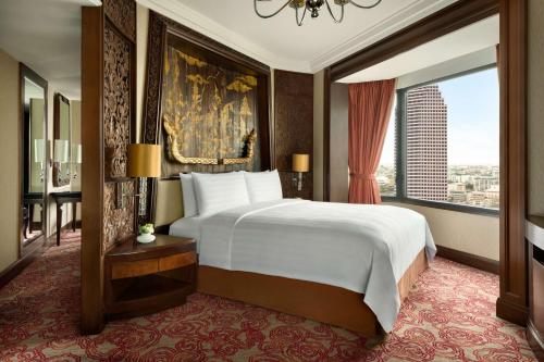 a bedroom with a large bed and a large window at Shangri-La Bangkok in Bangkok
