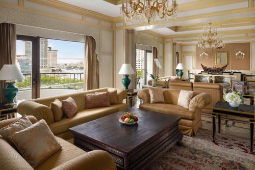 a living room with couches and a chandelier at Shangri-La Bangkok in Bangkok