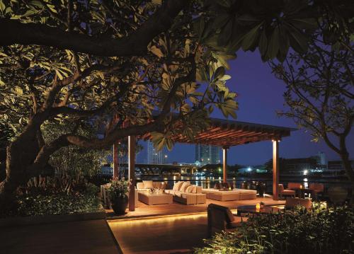 a gazebo with couches and tables at night at Shangri-La Bangkok in Bangkok
