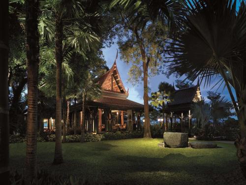 a resort with palm trees in front of a building at Shangri-La Bangkok in Bangkok