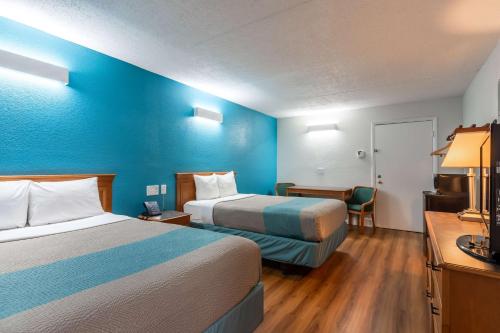 a hotel room with two beds and a blue wall at Motel 6-North Little Rock, AR - McCain in North Little Rock