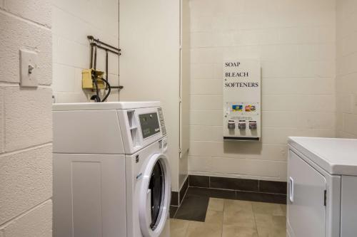 a laundry room with a washing machine and a sign at Motel 6-North Little Rock, AR - McCain in North Little Rock