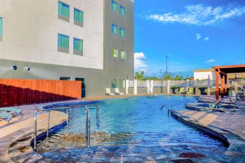 a large swimming pool in front of a building at La Quinta by Wyndham McAllen Convention Center in McAllen