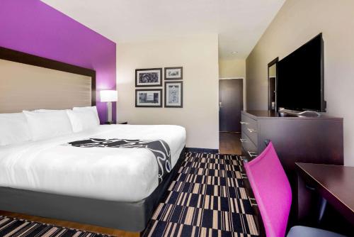 a hotel room with a large bed and a desk at La Quinta by Wyndham McAllen Convention Center in McAllen