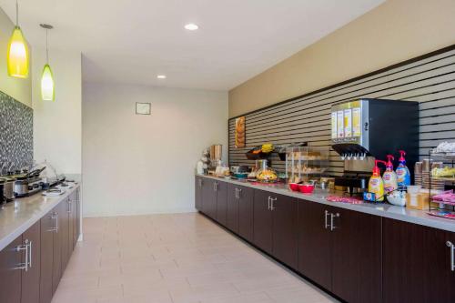 a kitchen with brown cabinets and a counter top at La Quinta by Wyndham McAllen Convention Center in McAllen