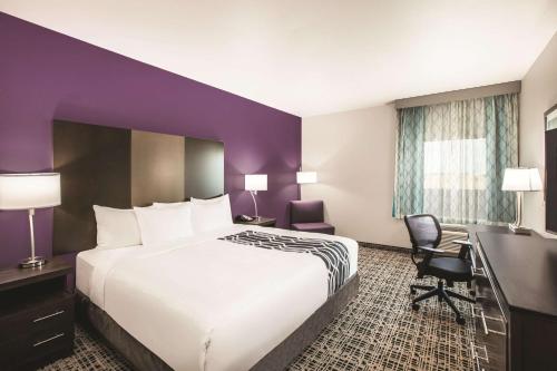 a hotel room with a large bed and a desk at La Quinta by Wyndham Lubbock South in Lubbock