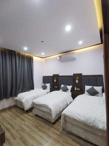 pokój z 3 łóżkami i oknem w obiekcie Private Sand Bond w mieście Al Raka