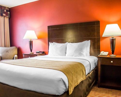 Comfort Inn & Suites في Dayville: سرير كبير في غرفة الفندق مع مصباحين