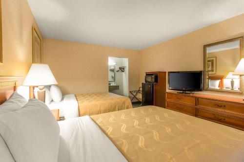 a hotel room with two beds and a flat screen tv at Quality Inn & Suites McDonough South I-75 in McDonough
