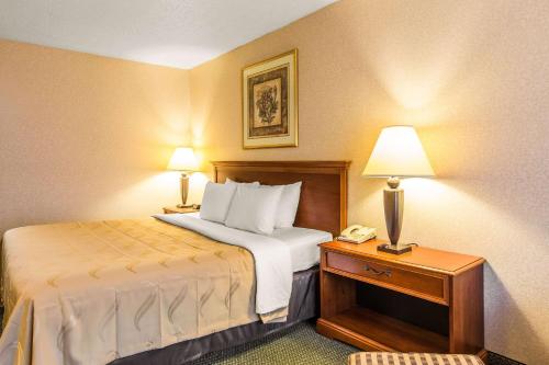 a hotel room with a bed and a telephone at Quality Inn & Suites McDonough South I-75 in McDonough