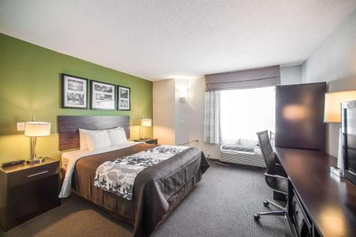 LarkdaleにあるSleep Inn Decatur I-72のベッドとテレビが備わるホテルルームです。