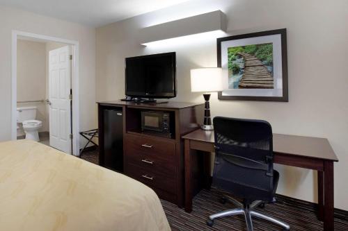 a hotel room with a desk and a bed and a television at Quality Inn Seneca Clemson Area U S 123 in Seneca