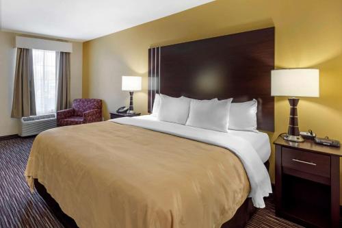 a hotel room with a large bed and a chair at Quality Inn Seneca Clemson Area U S 123 in Seneca