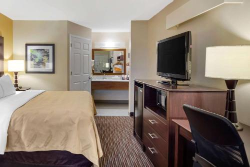 a hotel room with a bed and a flat screen tv at Quality Inn Seneca Clemson Area U S 123 in Seneca