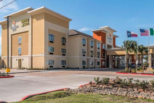 a hotel with flags in front of a building at MainStay Suites Edinburg South in Edinburg
