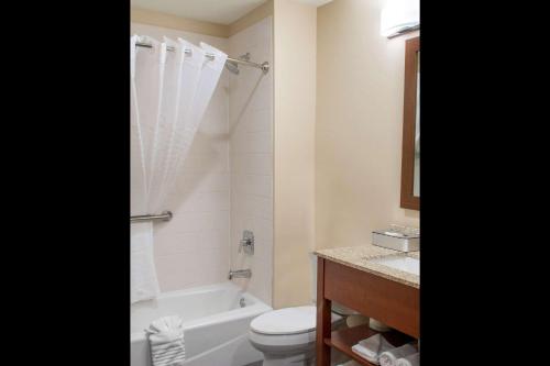 a bathroom with a tub and a toilet and a sink at MainStay Suites Edinburg in Edinburg