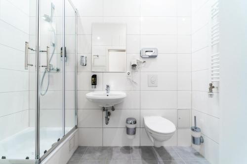 a bathroom with a toilet and a sink and a shower at Upper Room Hotel Kurfürstendamm in Berlin