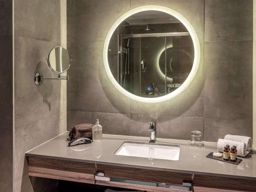 a bathroom sink with a mirror above it at Pullman Santiago El Bosque in Santiago