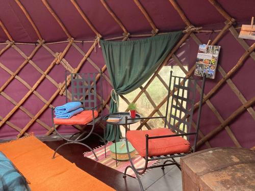 a room with two chairs and a table in a yurt at Jurtta Linkkumylly in Mäntyharju