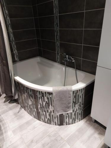 La salle de bains est pourvue d'une baignoire et d'une serviette. dans l'établissement Les Dauphins, à Saint-Romain-de-Jalionas