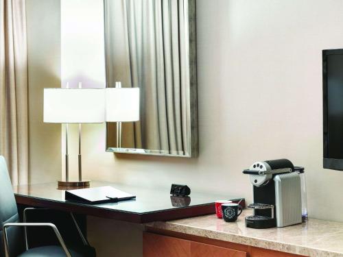 a desk with a monitor and a coffee cup at Swissôtel Al Ghurair Dubai in Dubai