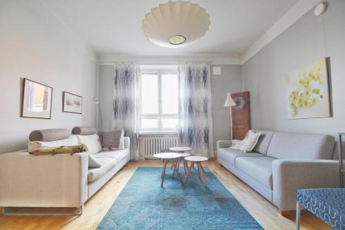 a living room with a couch and a table at HOMELY - City Apartment 50m2 in Helsinki