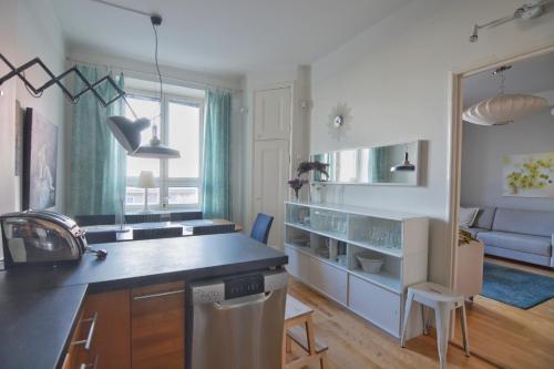 eine Küche mit einer Theke und ein Wohnzimmer in der Unterkunft HOMELY - City Apartment 50m2 in Helsinki
