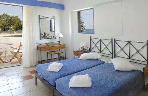 Porto Ligia في ليغيا: غرفة نوم بسريرين عليها مناشف